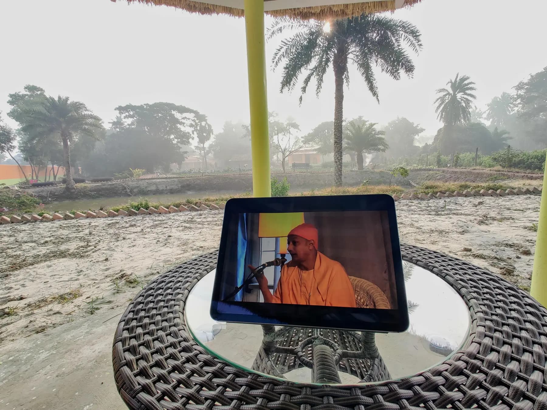 Tablet showing a Vedanta talk on a garden table on a misty winter morning