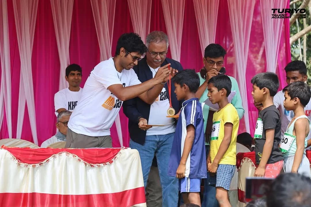 A boy receives his medal on stage at the Khejuri Mini Marathon prize-giving