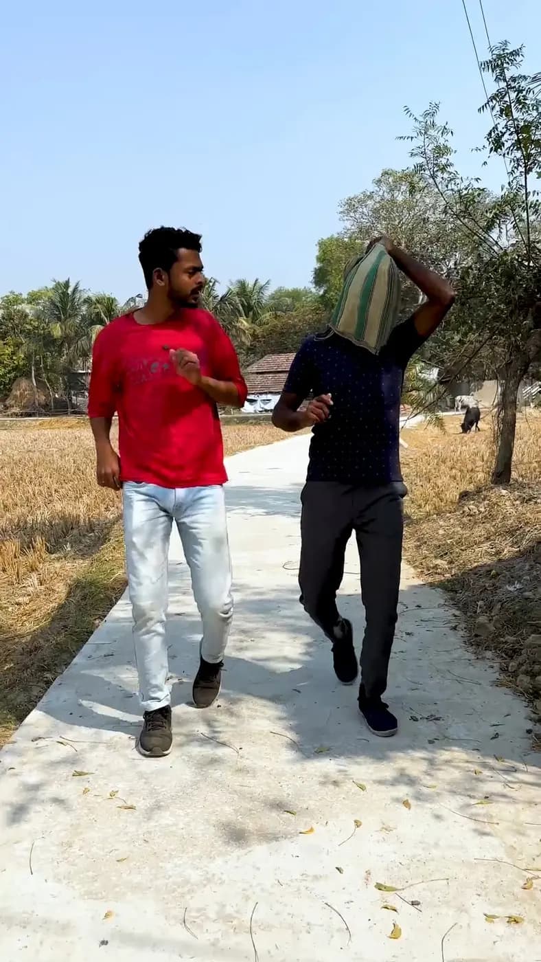 A young man in a red T-shirt jogs along a village path while training for the race