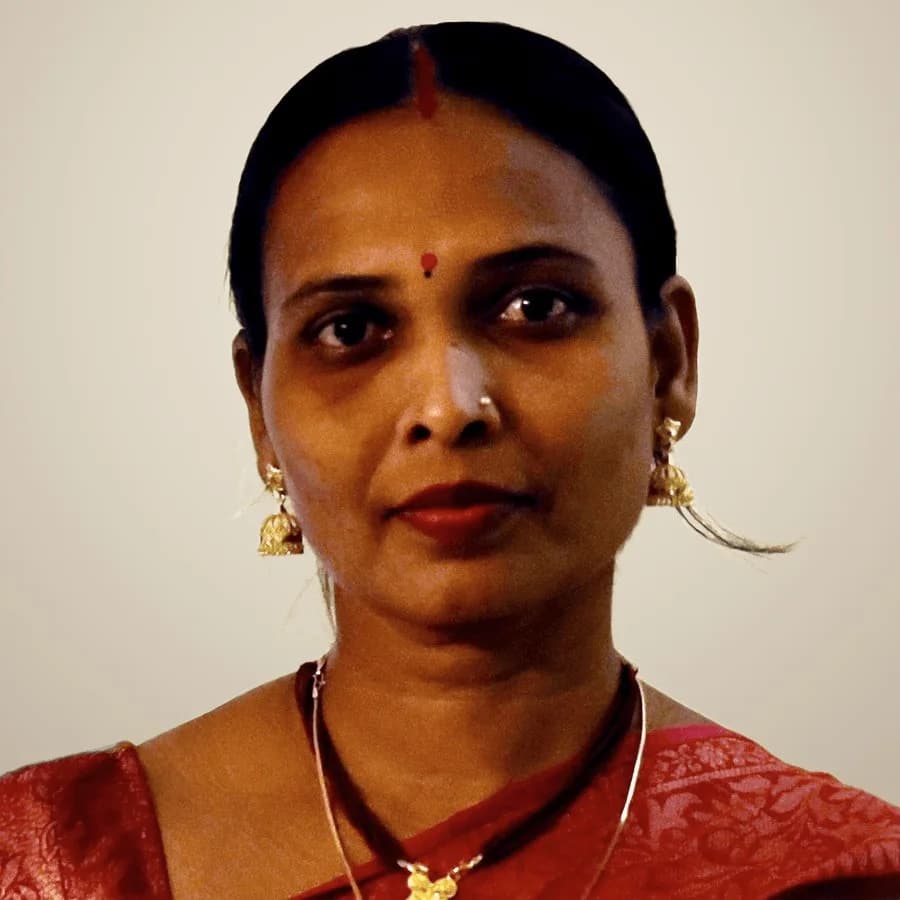 Portrait of Shilpa Sarkar Maiti in a red sari and gold earrings