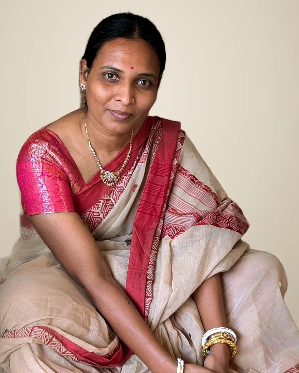 Shilpa Sarkar Maiti, the residency's trainer, seated, in a cream and red sari