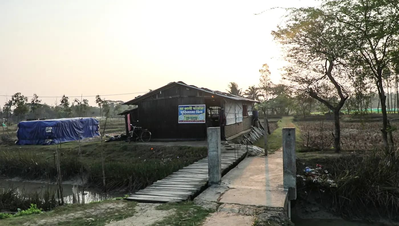 Puffed rice mill shed with a wooden footbridge at sunset