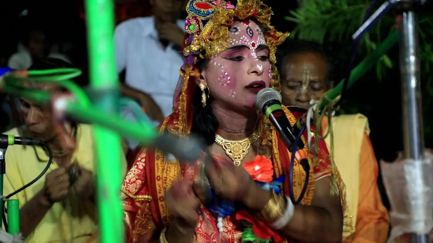 Costumed lead singer performing at a night-time puja