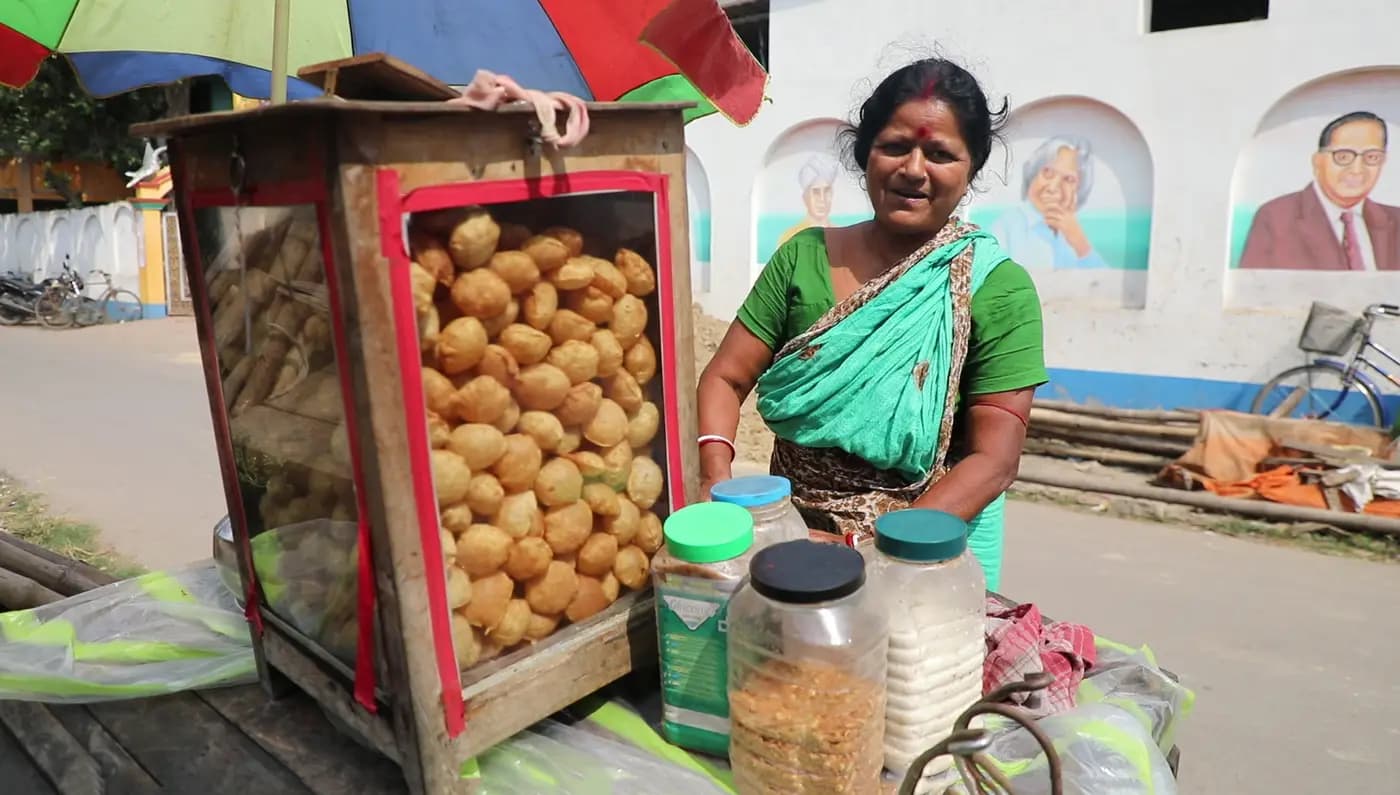 Panipuri Auntie smiling behind her panipuri cart
