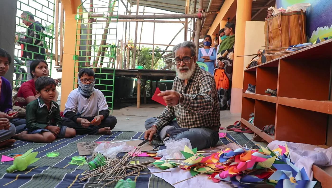 Sudip Maiti teaching children to make paper pinwheels