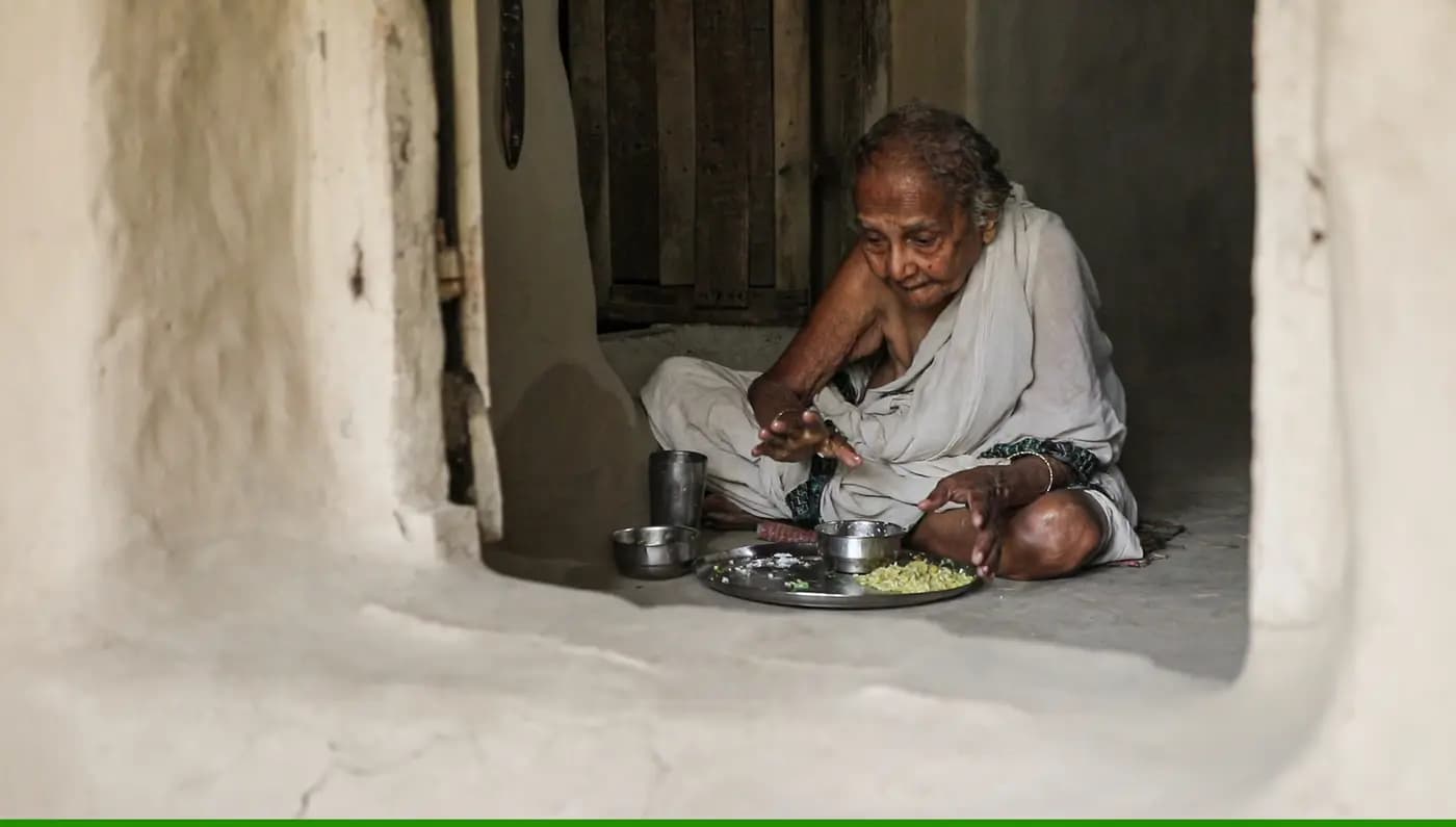 Gitarani Maity eating a meal in her mud house
