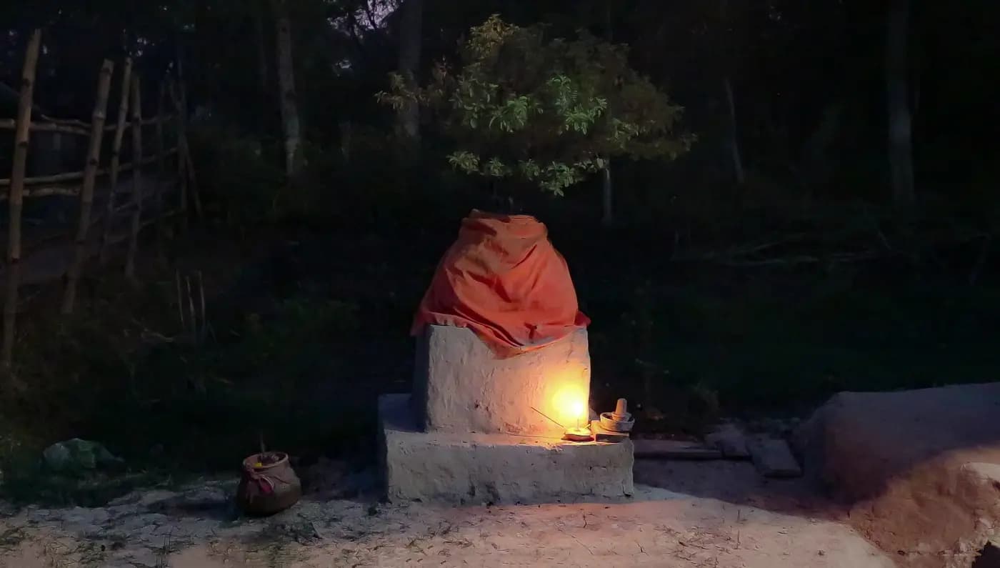Lamp-lit tulsi shrine at dusk