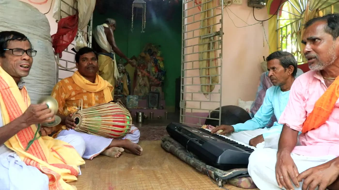 Vaishnavite singers with khol and keyboard at a puja