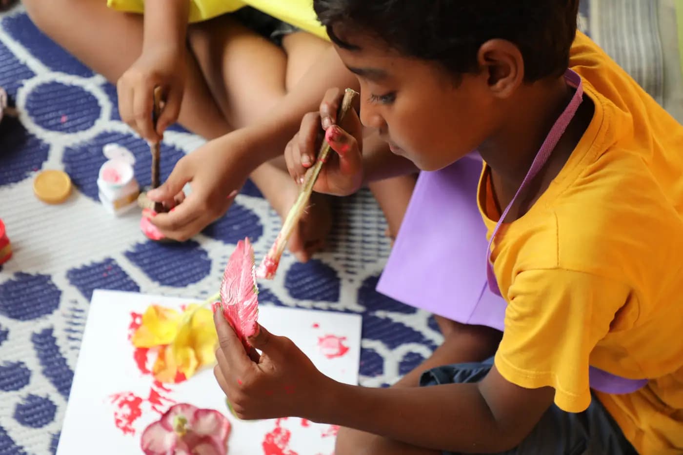 Boy making leaf prints with paint