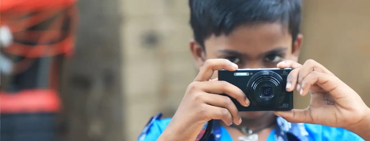 Boy taking a photo with a compact camera