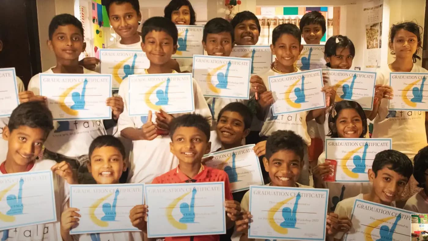 Children holding FALA graduation certificates