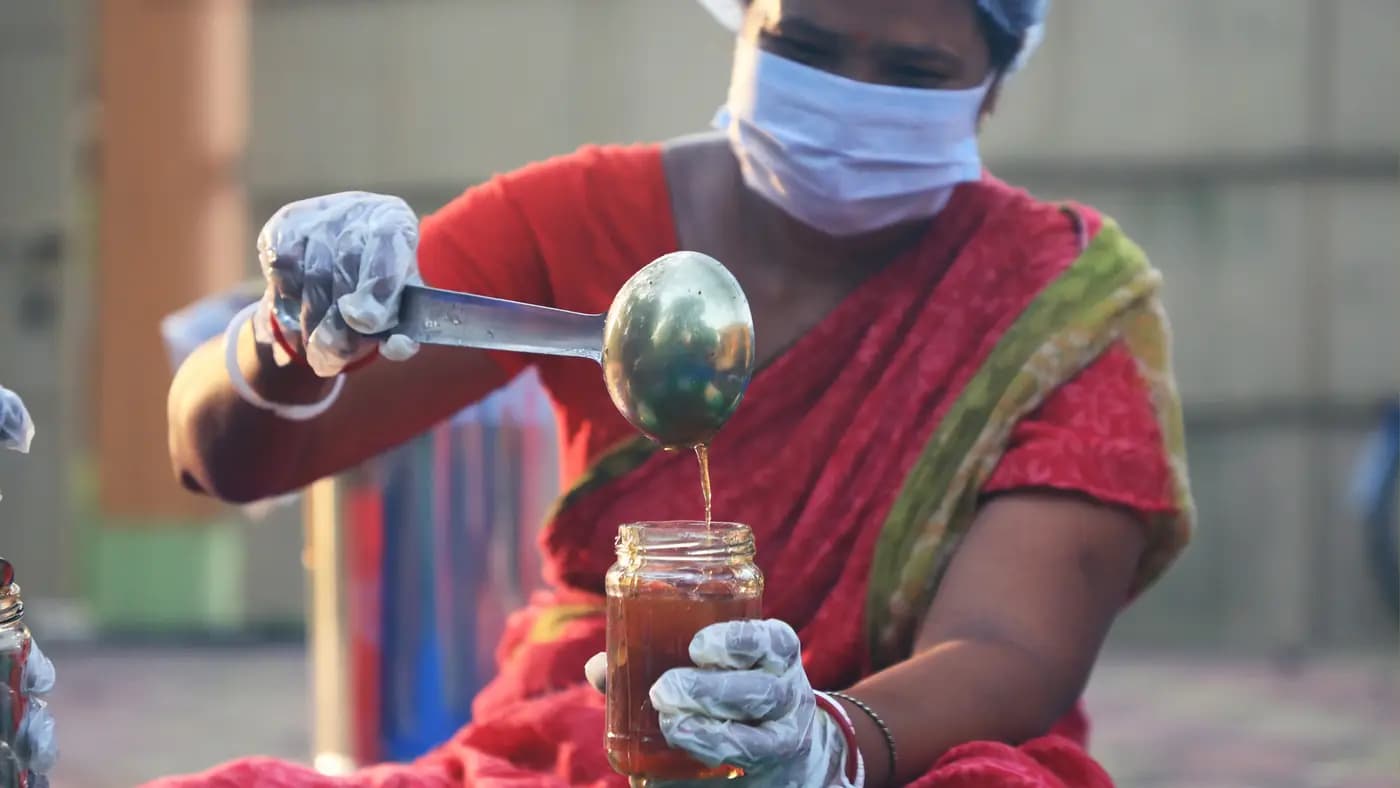 Woman ladling pickle into a jar