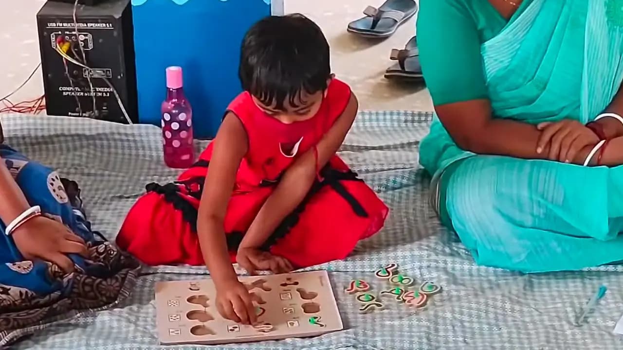 Small girl playing with a wooden learning kit