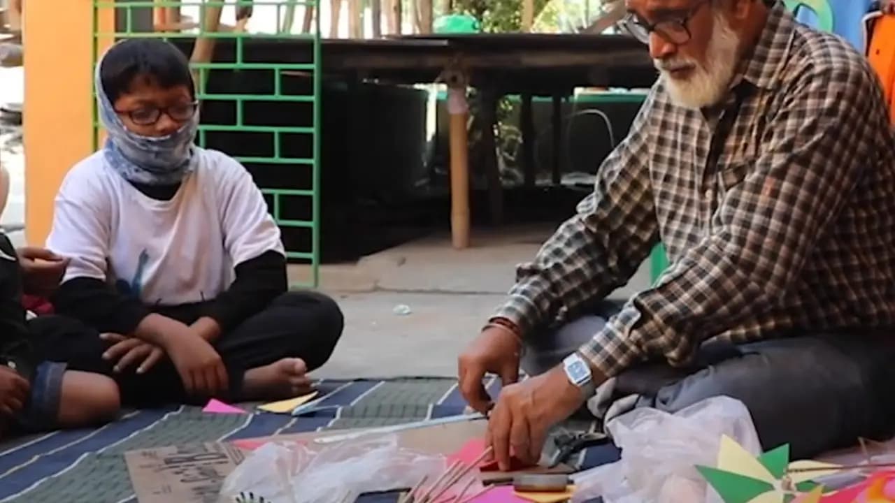 Artist and boy making decorations for Saraswati Pujo