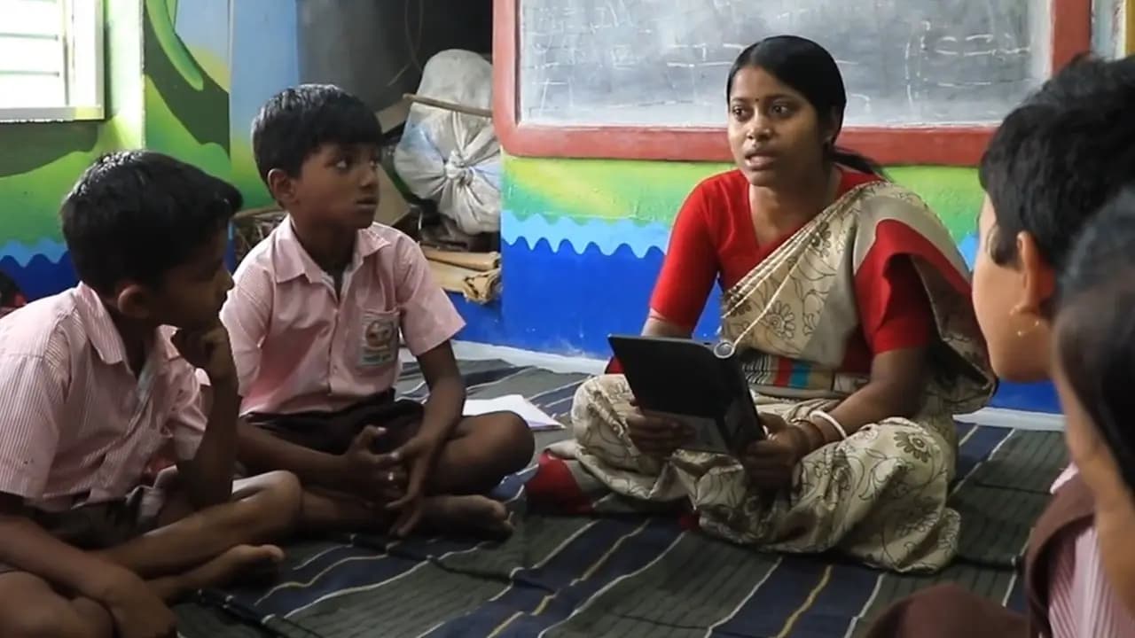 Teacher with a tablet talking to nursery boys
