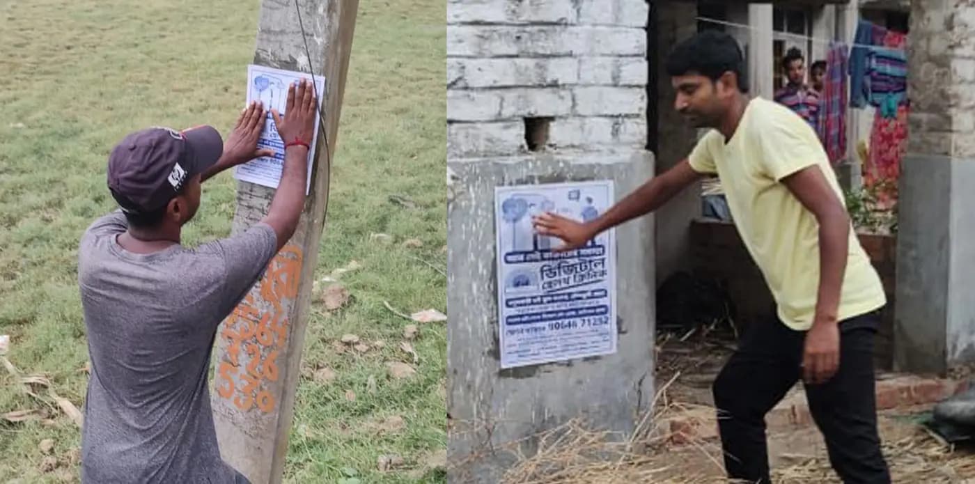 Men pasting clinic posters in the village