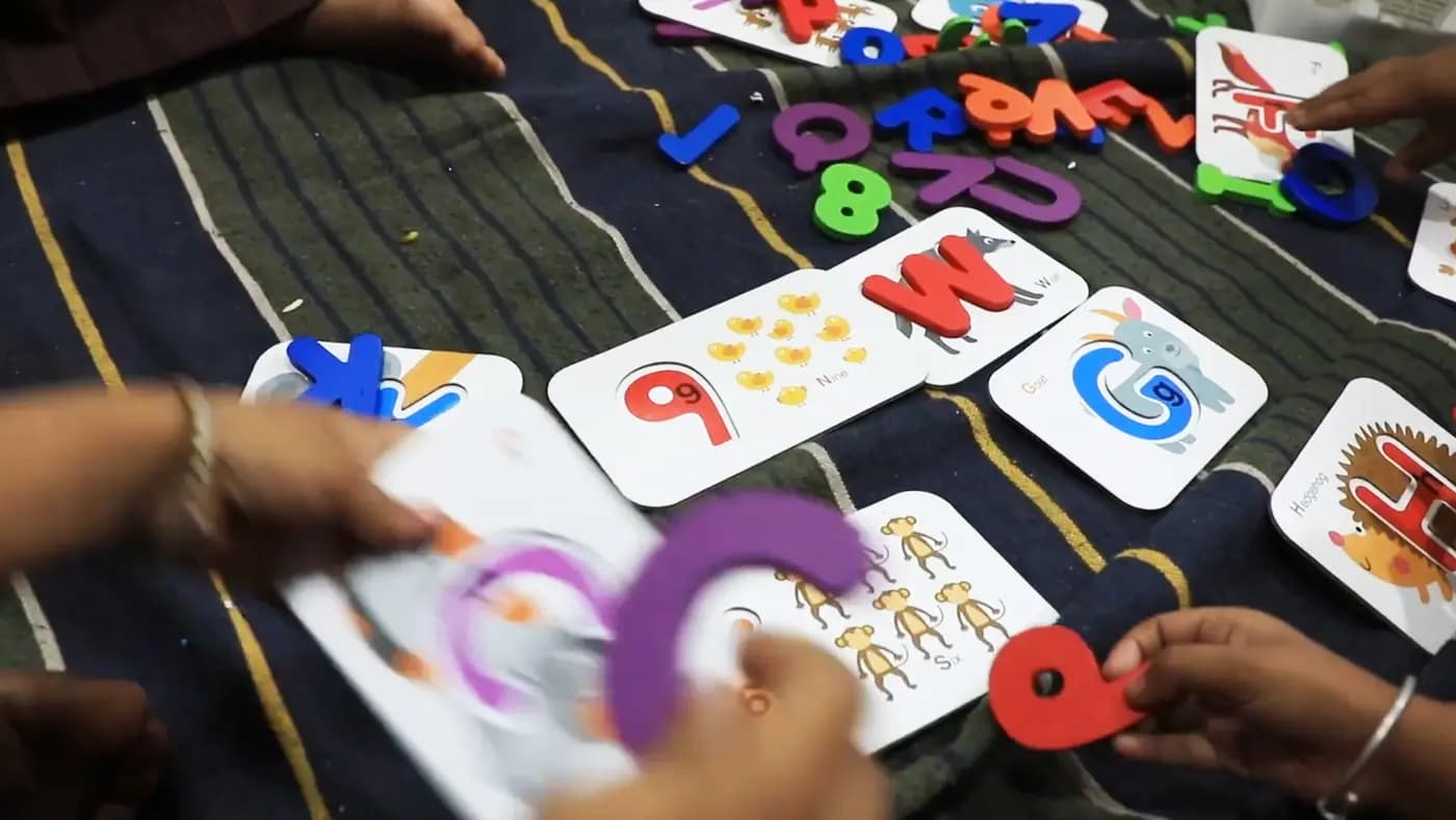 Children's hands with foam letters and alphabet cards