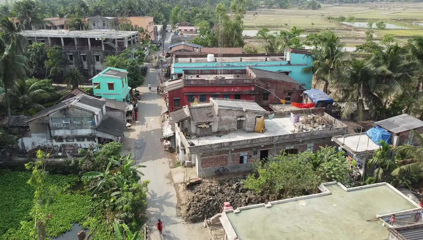 Aerial view of a Chauddhachuli street with houses and palms