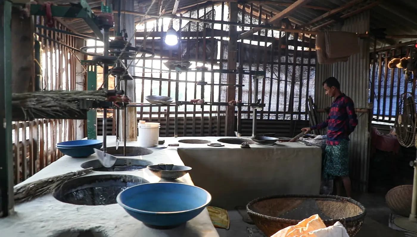 Worker at clay ovens inside the puffed rice mill